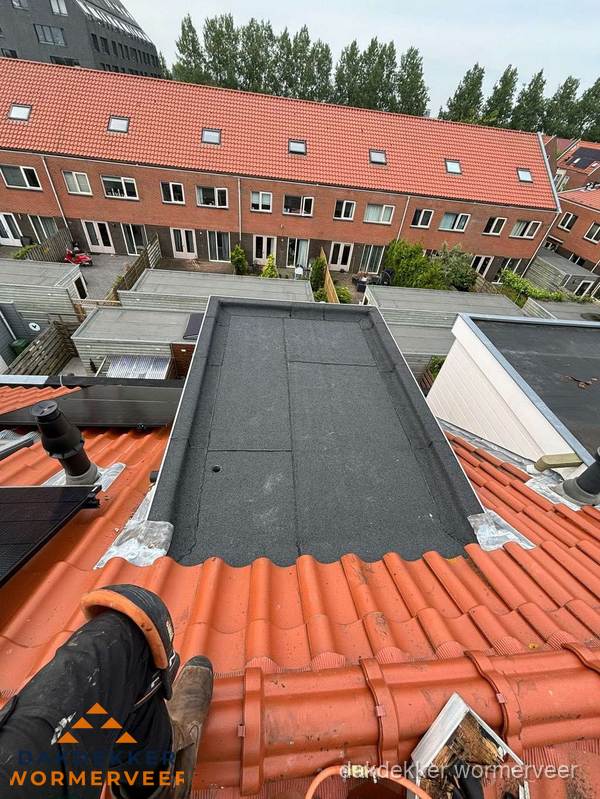 Bitumen dak reparatie op plat dak tussen dakpannen in Wormerveer