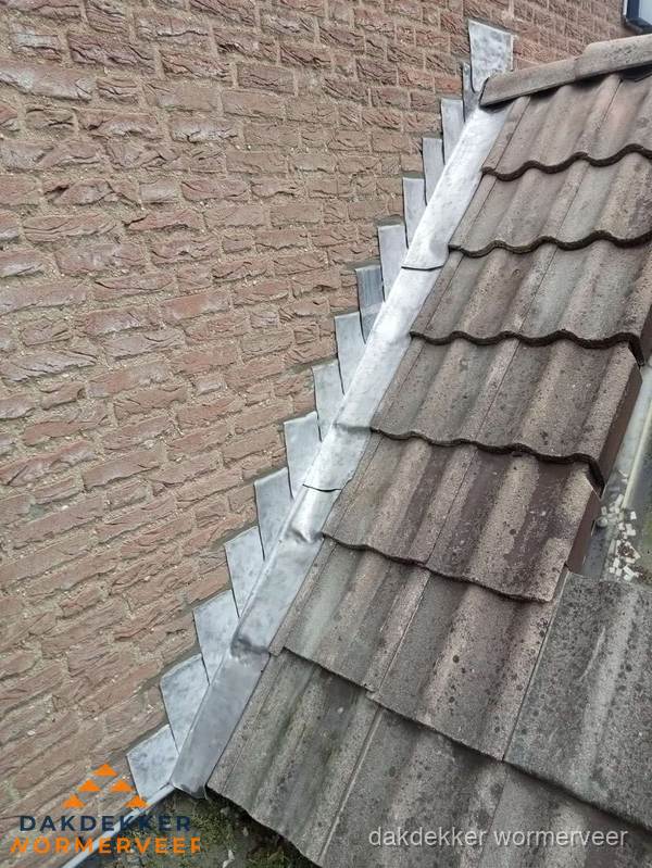 Loodslabben langs dakaansluiting bij bakstenen muur in Wormerveer