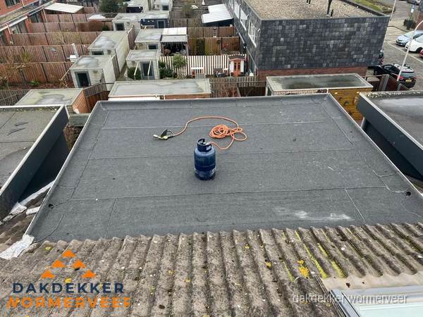 Plat dak met nieuwe bitumen dakbedekking en brandgereedschap in Wormerveer