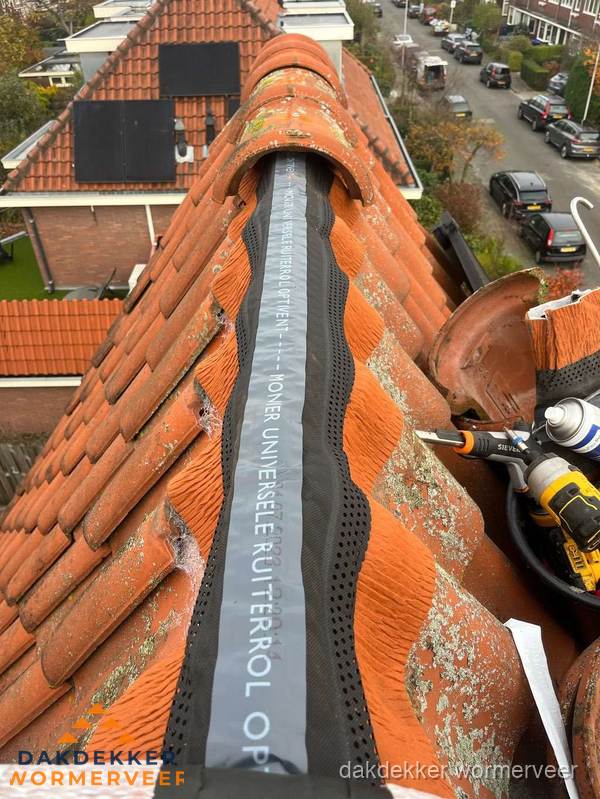Dakdekker vervangt nokvorst met ruiterrol op pannendak in Wormerveer