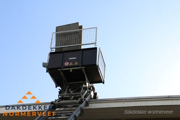 Dakdekkerslift voor materiaal transport bij dakwerkzaamheden in Wormerveer