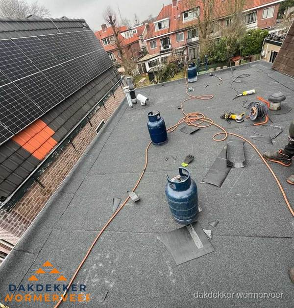 Daklekkage repareren met brandgereedschap op plat dak in Wormerveer