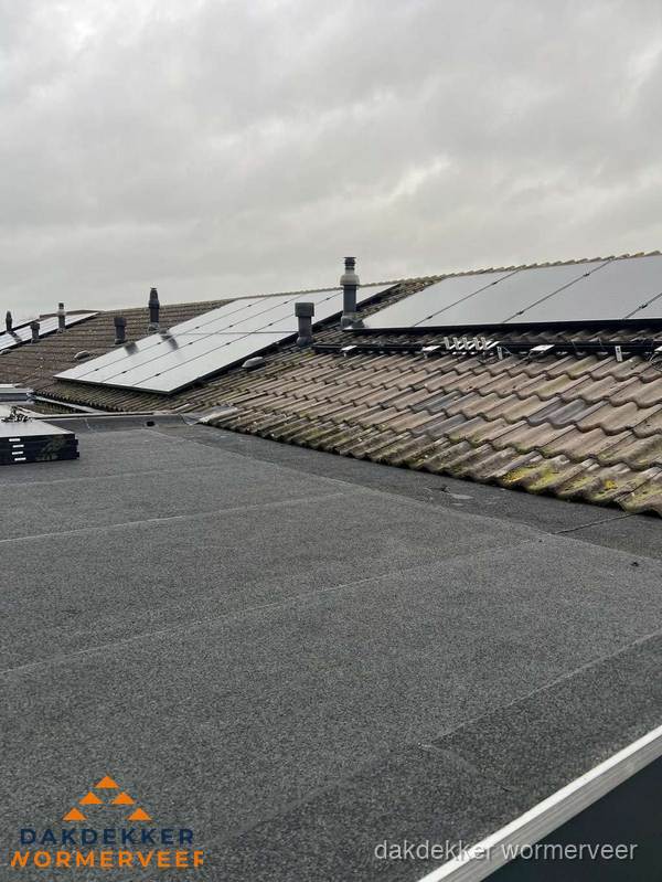 Bitumen dakbedekking op plat dak met aansluitend pannendak en zonnepanelen in Wormerveer