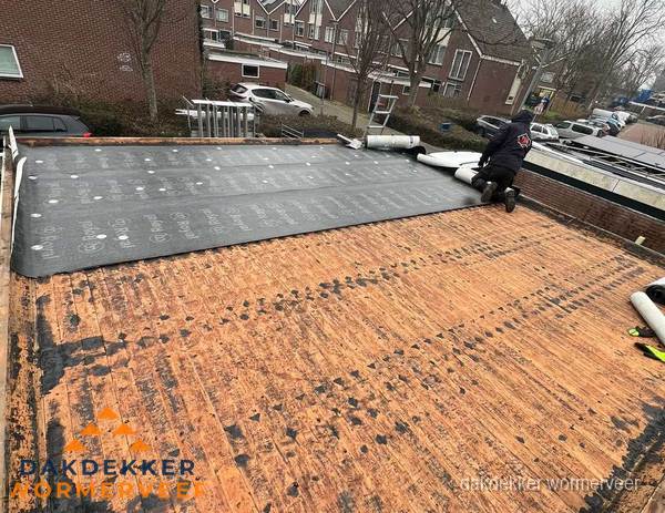 Dakdekker legt onderlaag op plat dak met houten constructie in Wormerveer