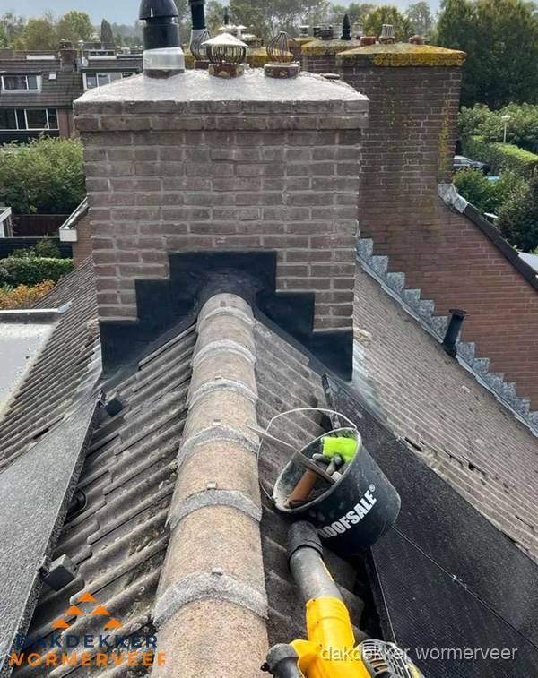 Schoorsteen met loodaansluiting en nokvorst op pannendak in Wormerveer