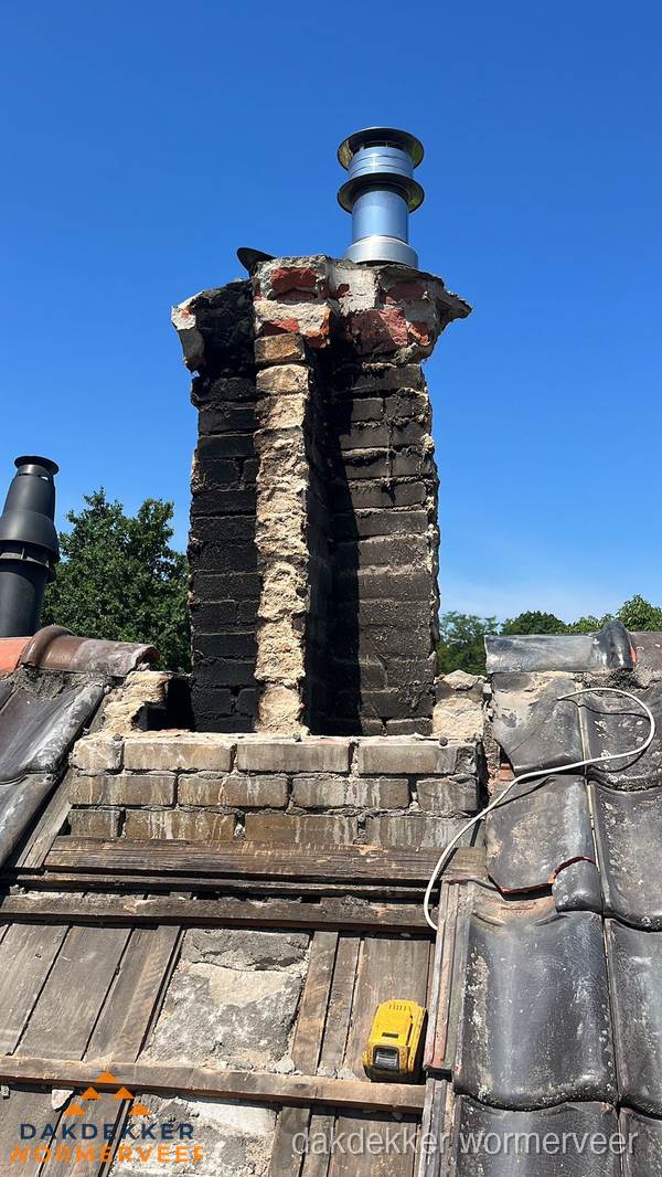 Beschadigde schoorsteen met nieuwe rookgasafvoer op oud dak in Wormerveer