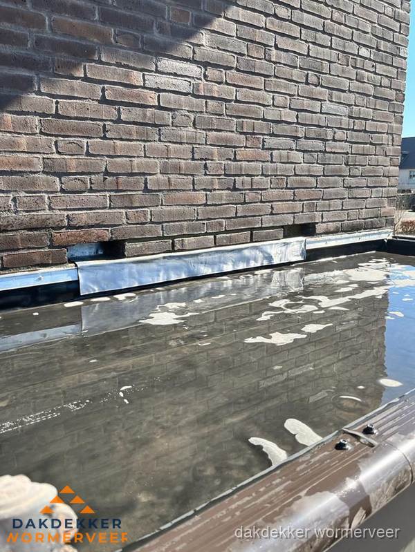 Stilstaand water op plat dak door slechte afwatering in Wormerveer