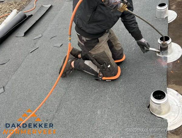 Dakdekker repareert bitumen dakleer bij dakdoorvoer in Wormerveer