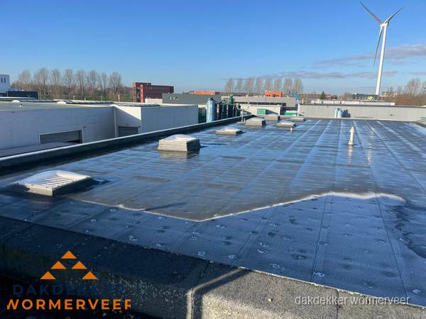 Plat dak bedrijfspand met bitumen dakbedekking en lichtkoepels in Wormerveer